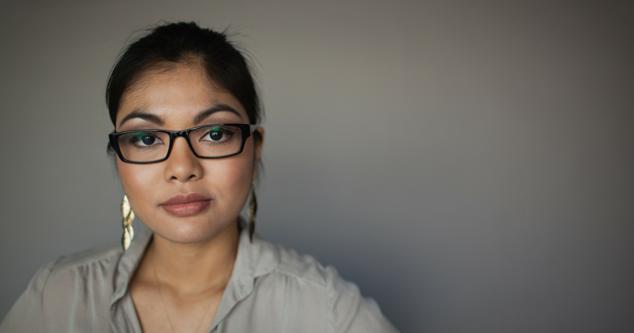 A woman looks very seriously into the camera