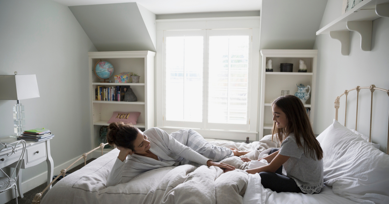 A mother and daughter in bed talking