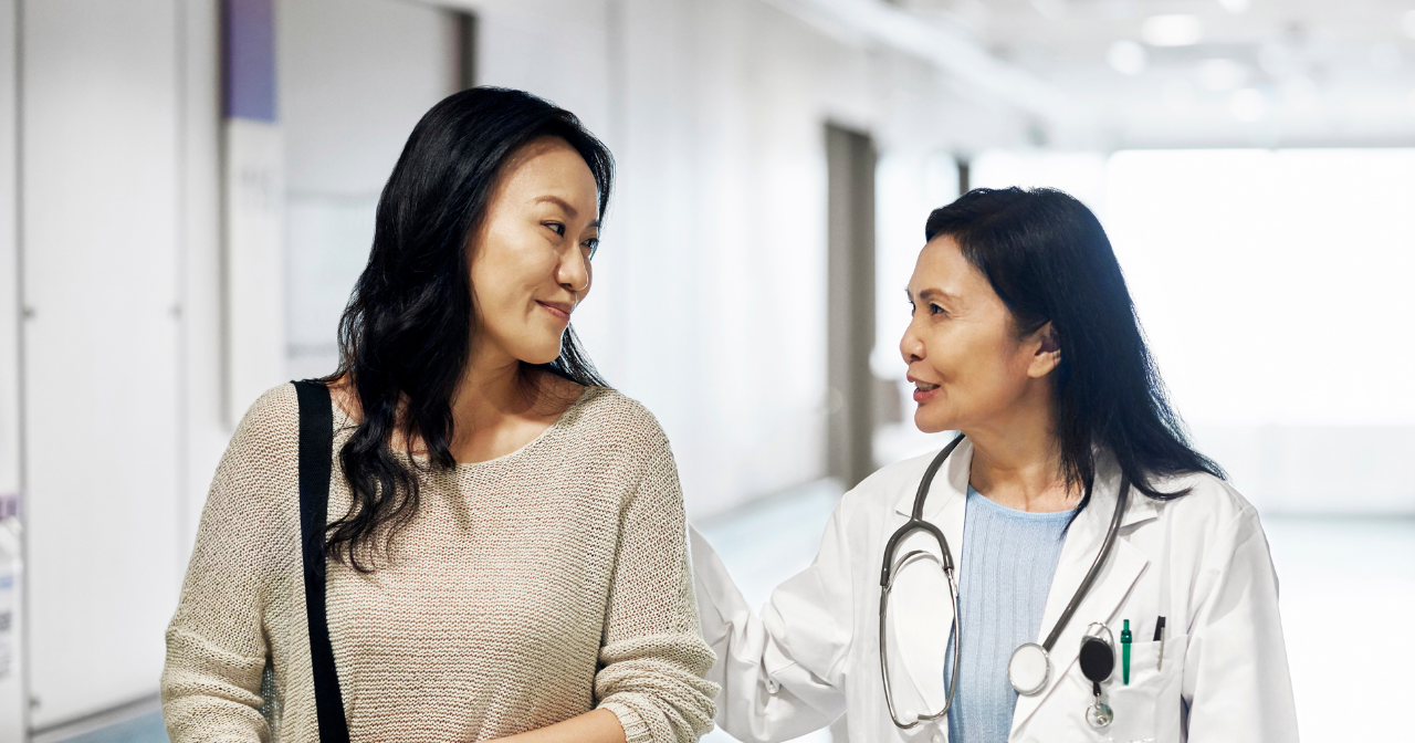 A provider and patient talk while walking down a hallway. 