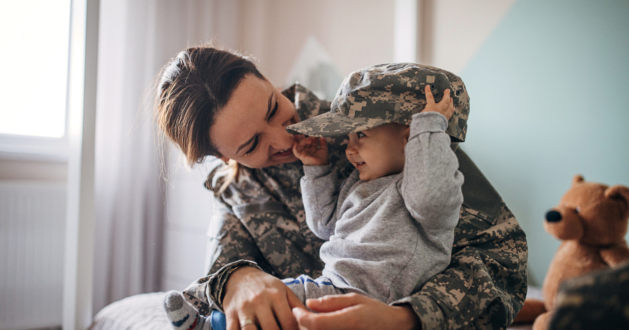 A female Marine smiles and laughs with her young son. 