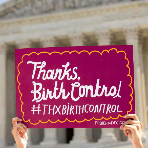 Hands holding a sign that reads, "Thanks, Birth Control #ThxBirthControl" outside the Supreme Court. 