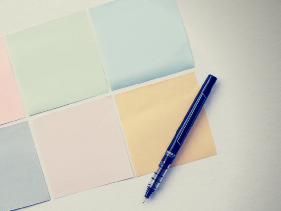 six blank sticky notes with a pen
