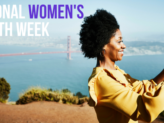 A woman takes a selfie at the Golden Gate Bridge with the words, "National Women's Health Week" behind her