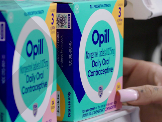 An image of a hand pulling a box of Opill off the shelf at a store. 