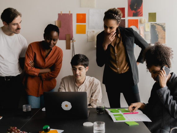 A photo of a team of men and women working together in an office. 