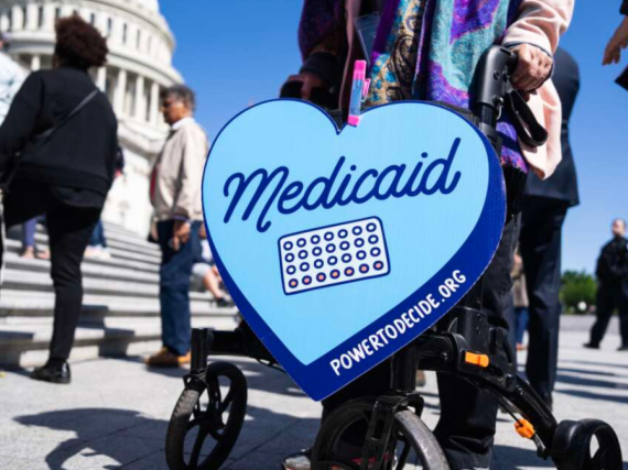 A heart sign supporting Medicaid being held outside the Capitol building. 