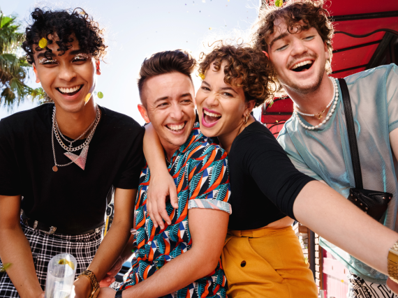 Friend group hugging and laughing.