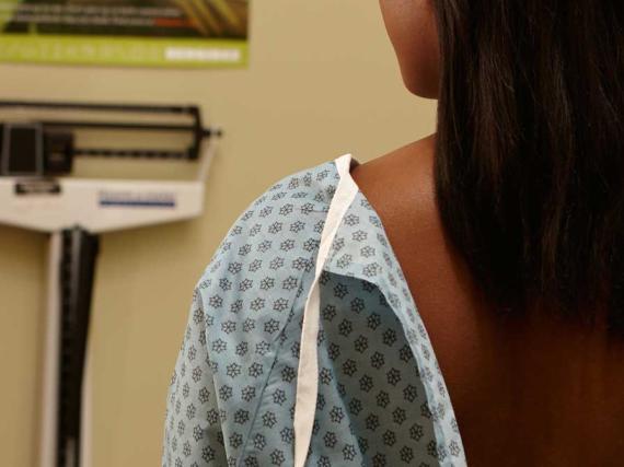 Woman in hospital gown with her back to the camera